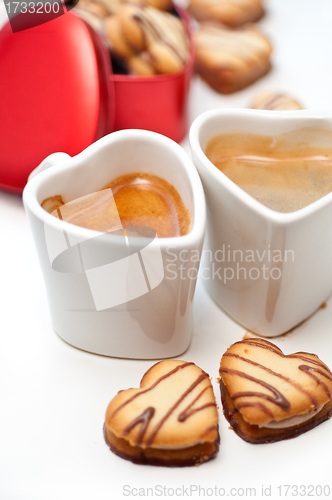 Image of heart shaped cream cookies on red heart metal box and coffee