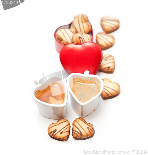 Image of heart shaped cream cookies on red heart metal box and coffee