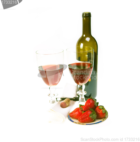 Image of red wine bottle and two glasses with strawberries