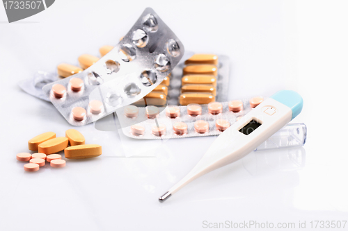 Image of Thermometer and pills isolated on white