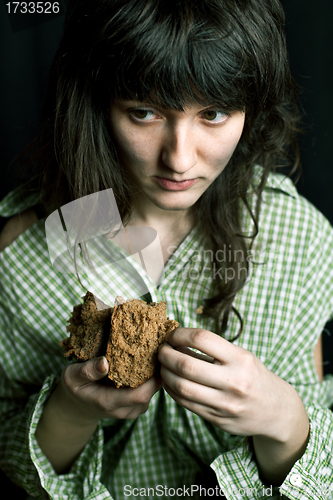 Image of poor beggar woman with a piece of bread