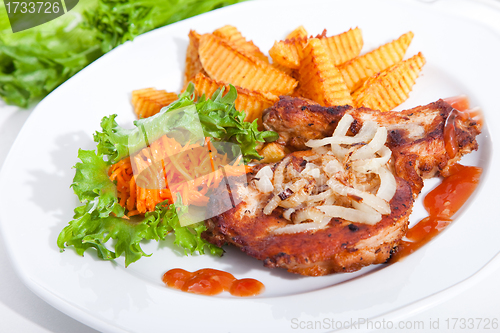 Image of steak served with sauteed onions, salad and baked potato