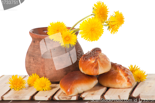 Image of three pies and dandelions in  clay pot