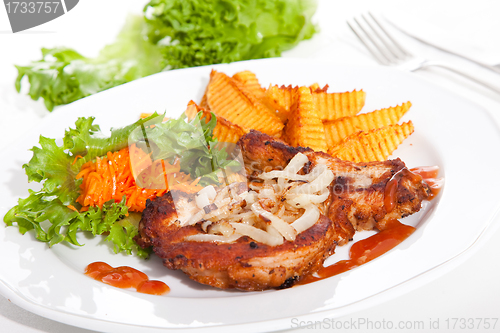 Image of steak served with sauteed onions, salad and baked potato