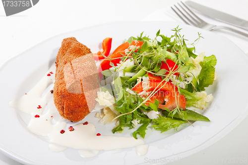 Image of garlic chicken kiev with mixed leaf salad