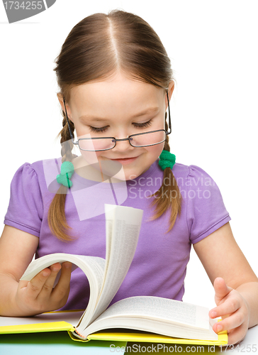Image of Cute cheerful little girl with book