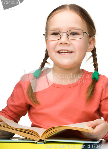 Image of Cute cheerful little girl with book
