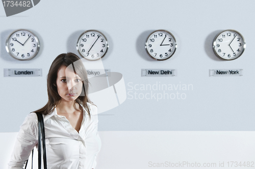 Image of Businesswoman In Front Of World Time Zone Clocks
