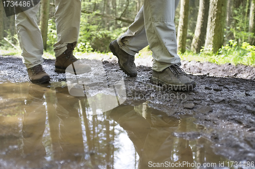 Image of Hikers Walking Through Mud Puddle