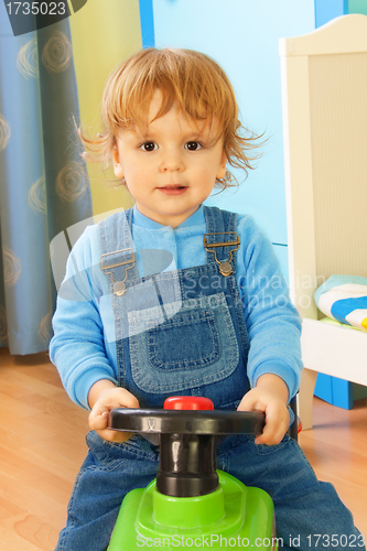 Image of Portrait of a boy riding a toy car