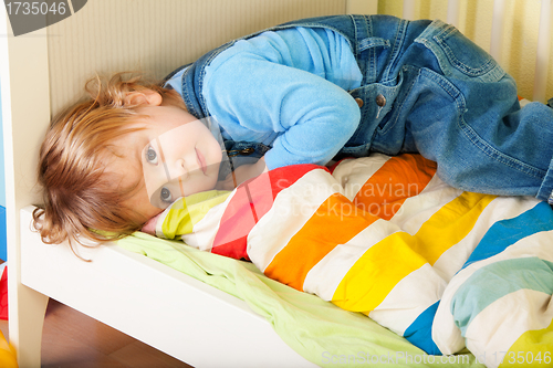 Image of Tired toddler laying in his bed