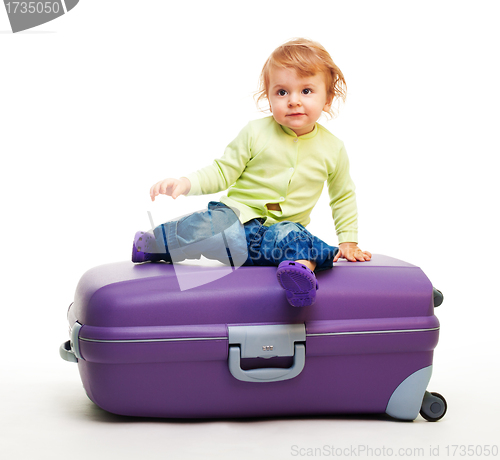 Image of Kid sit on the big suitcase