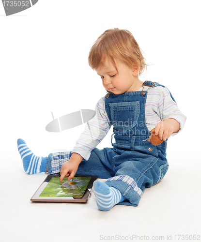 Image of Young kid playing with tablet pc