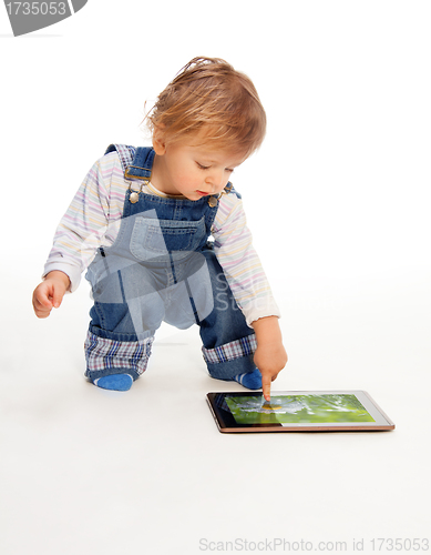 Image of young kid touching tablet pc