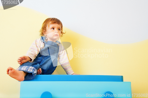 Image of Happy kid sitting on the furniture