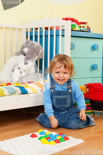 Image of Laughing boy playing with mosaic