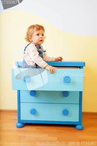 Image of Kid sitting inside cabinet box