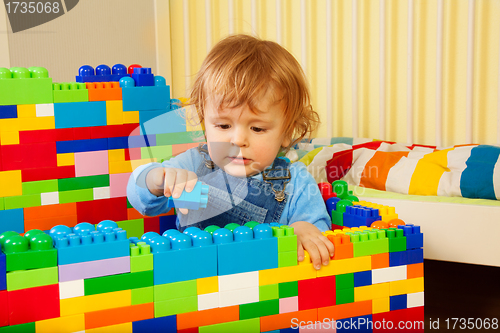 Image of Little boy playing with plastic blocks