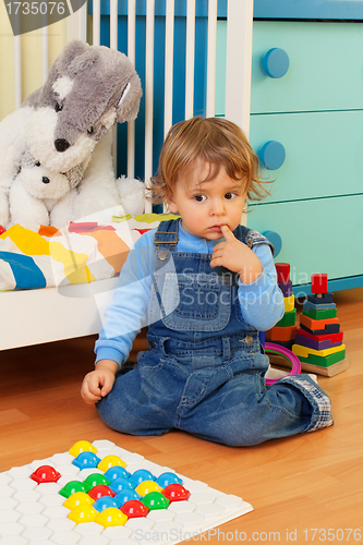 Image of Puzzled boy playing with mosaic