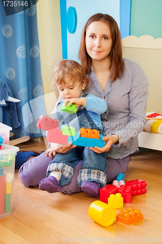Image of Mother and kid - playing with blocks