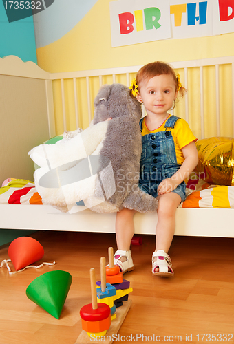 Image of Girl sitting in the baby bed with boys