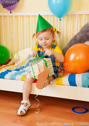 Image of Little girl opening the present