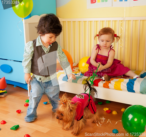 Image of Kids playing with dog and having party