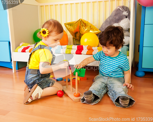 Image of boy and girl playing with toy pyramid puzzle