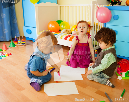 Image of Tree kids drawing sitting on the floor