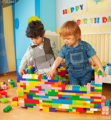 Image of Kids building a wall of plastic blocks
