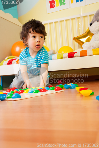 Image of ittle boy playing with mosaic