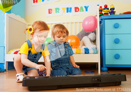Image of Girl with boy playing piano