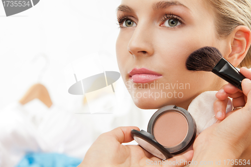 Image of Using blush brush to apply blush on cheeks