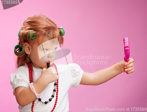 Image of Little girl playing with mothers makeup