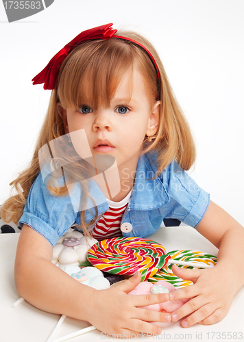 Image of Greedy  girl with pile of sweets