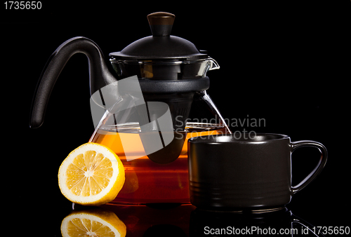 Image of Tea in transparent glass pot with lemon