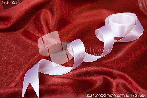 Image of White ribbon on red drape