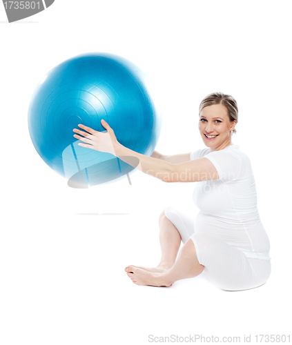 Image of Pregnant woman playing with exercise ball