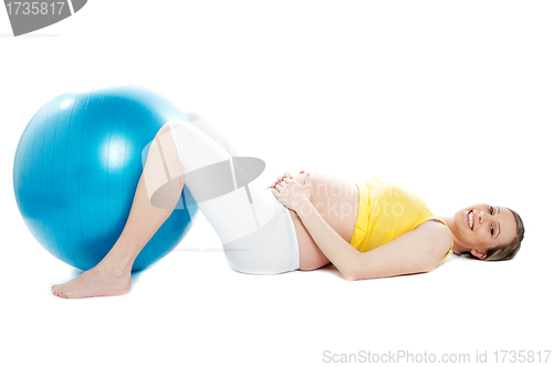 Image of Beautiful pregnant woman lying with exercise ball