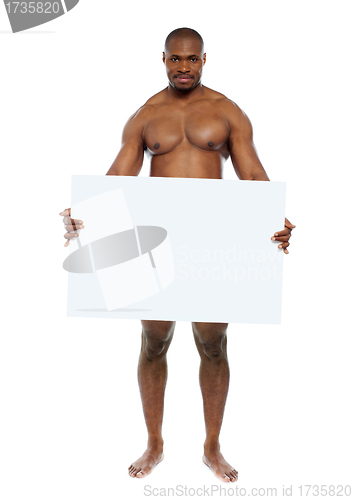 Image of Naked man hiding behind blank white billboard