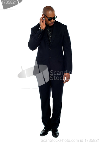 Image of African businessman trying to listen to something