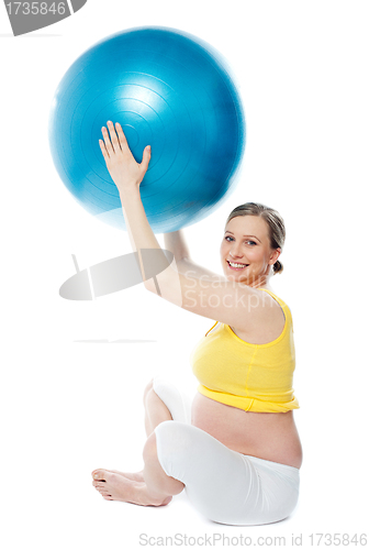 Image of Smiling pregnant woman with a ball