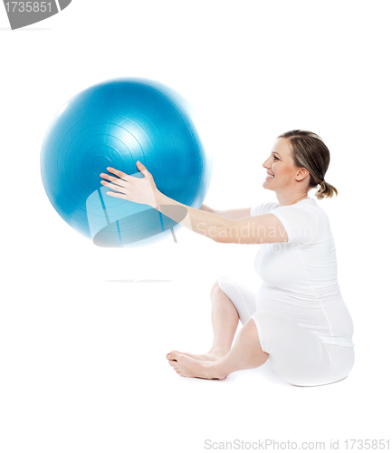 Image of Pregnant woman sitting with exercise ball