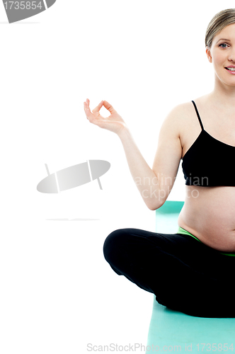 Image of Cropped image of a pregnant lady doing yoga