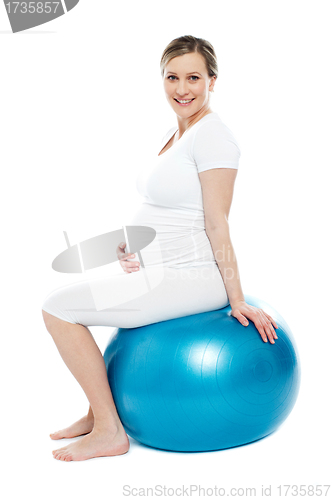 Image of Pregnant lady sitting on exercise ball