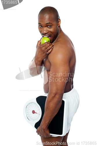 Image of Young man enjoying fresh green apple