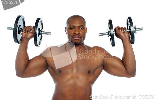 Image of Shirtless african male holding dumbbells