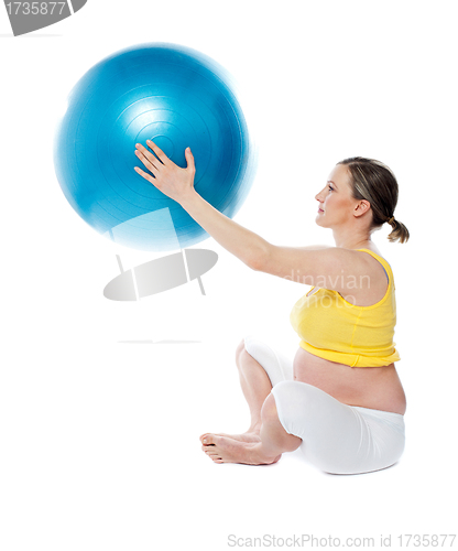Image of Attractive pregnant lady practicing yoga