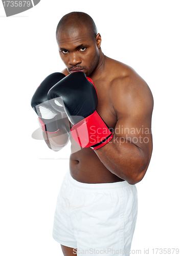 Image of Shirtless african boxer aiming to punch you