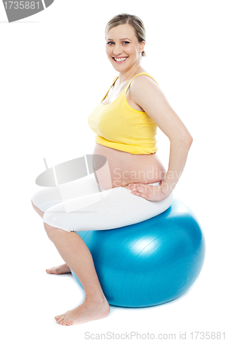 Image of Pregnant woman exercises with gymnastic ball
